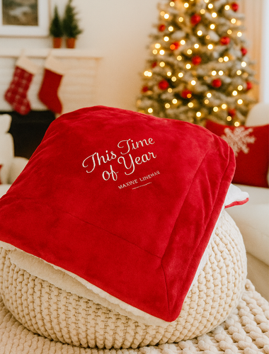 Red blanket with 'This Time of Year' text in a festive living room with Christmas tree and stockings.

Details